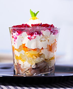 Salad herring under fur coat from vegetables in verrin on black plate