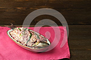 Salad herring under a fur coat on a wooden table in the backgro