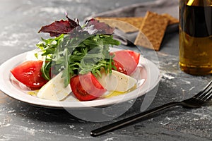 Salad of juicy, red, large tomatoes and buffalo mozzarella, with arugula