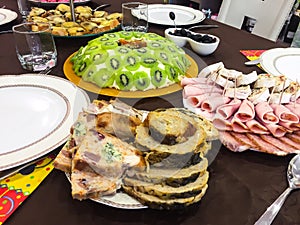 Salad with kiwi, ham, pieces of stuffed turkey, rolls with salmon at a Christmas dinner