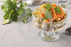 Salad with Korean carrots, meat and canned peas in transparent salad bowl a gray background, Copy space