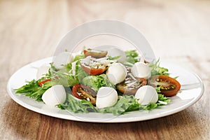 Salad with kumato tomato, mozzarella, frillies lettuce and grated parmesan