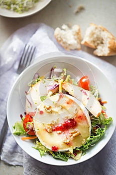 Salad with lettuce, brie, fried pears, camembert, walnuts, red onion, tomatoes and raspberry vinaigrette dressing