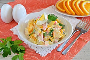 Salad made of orange, crab meat, eggs, corn served with yogurt in a white bowl on a cloth background. Simple food