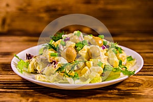 Salad with marinated mushrooms, eggs, red onion, boiled potato and mayonnaise on wooden table