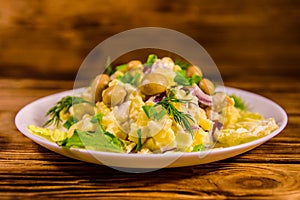 Salad with marinated mushrooms, eggs, red onion, boiled potato and mayonnaise on wooden table