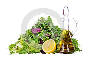 Salad mix with bottle of olive oil and lemon isolated on white