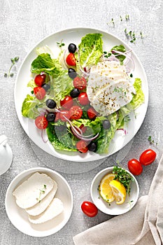 Salad with mozzarella cheese, cherry tomato, olives and romain lettuce, top view