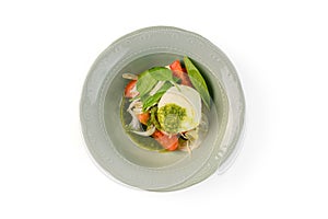 Salad mozzarella with vegetables in plate on white background. Top view