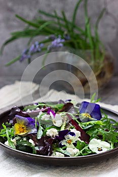 Salad of pansies and herbs seasoned with vegetable oil, lemon juice and spices