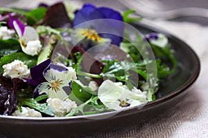 Salad of pansies and herbs seasoned with vegetable oil, lemon juice and spices