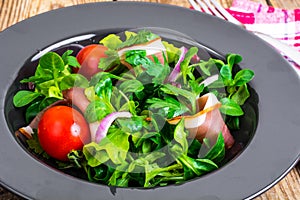 Salad with parma ham jamon, tomatoes and fresh herbs