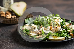 Salad of pear, blue cheese, arugula and nuts with spicy dressing