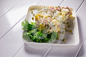 Salad with peas, mayonnaise, potatoes, sausage, cabbage, carrots and eggs