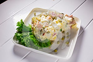 Salad with peas, mayonnaise, potatoes, sausage, cabbage, carrots and eggs