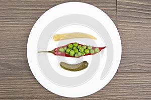 Salad of pickled and pickled corn, peas, cucumber and red pepper on a white plate.  food and vegetables. diet and weight loss