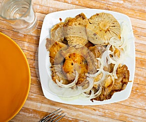 Salad of pickled wild mushrooms and sliced onion on plate