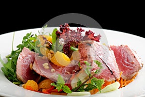 Salad with pieces of medium-rare grilled tuna