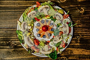 Salad Plate with Fruit Salad in the middle on wooden table