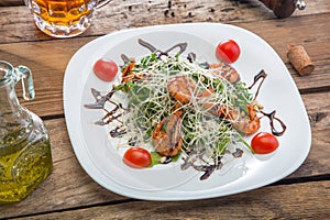 Salad on a plate with tomatoes and shrimps