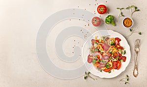 Salad with Prosciutto, tomatoes, onion, sweet pepper and broccoli. Cold snacks. Top view. Free space for your text.