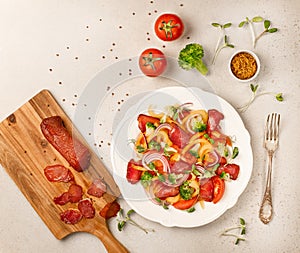 Salad with Prosciutto, tomatoes, onion, sweet pepper and broccoli. Cold snacks. Top view. Free space for your text.