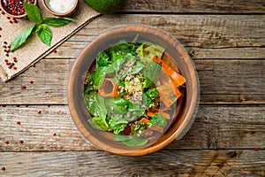 Salad with quinoa and shpinach on wooden table