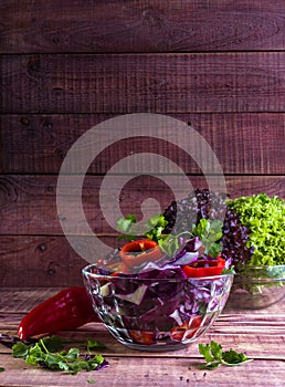 Salad of red cabbage and sweet red pepper, seasoned with lemon juice and olive oil in wooden table