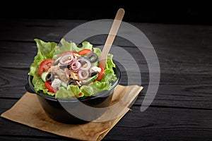 Salad with red fish or tuna and lettucce in a plastic bowl. Healthy fast food.