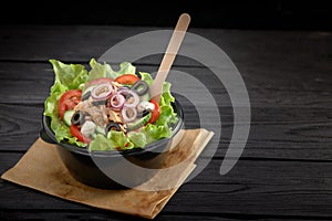 Salad with red fish or tuna and lettucce in a plastic bowl. Healthy fast food.