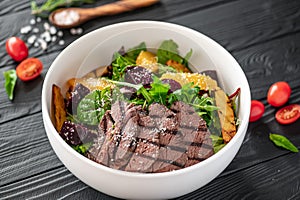 Salad with roast beef and caramelized beets with orange fillet, potatoes, parmesan, salad mix and olive oil