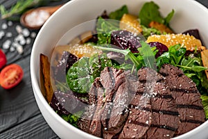 Salad with roast beef and caramelized beets with orange fillet, potatoes, parmesan, salad mix and olive oil