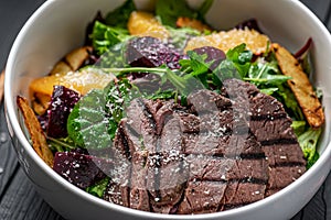 Salad with roast beef and caramelized beets with orange fillet, potatoes, parmesan, salad mix and olive oil