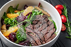 Salad with roast beef and caramelized beets with orange fillet, potatoes, parmesan, salad mix and olive oil