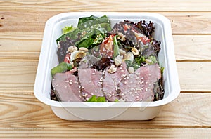 Salad with roast beef sous-vide. Healthy food. Takeaway food. On a wooden background