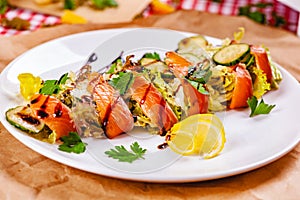 Salad with salmon, cucumber and mixed greens on white plate