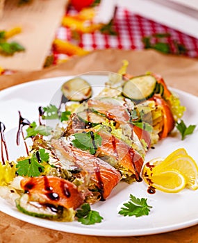 Salad with salmon, cucumber and mixed greens on white plate