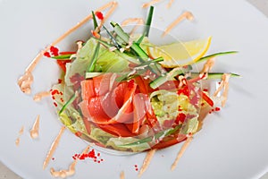Salad with salmon and iceberg lemon, cucumber, pink sauce,