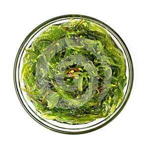 Salad of seaweed Chuka in a glass plate on a white. The form of the top.