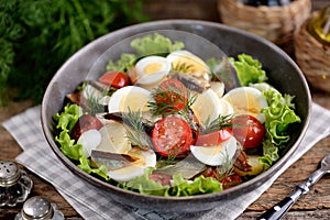 Salad with smoked fish, potatoes, cherry tomatoes and a boiled egg.
