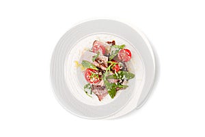 Salad with smoked ham and arugula in the white ceramic plate