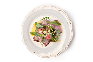 Salad with smoked ham and arugula in the white plate top view