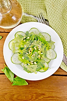 Salad from spinach and cucumber with cedar nuts on board top