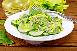 Salad from spinach and cucumber with fork on board