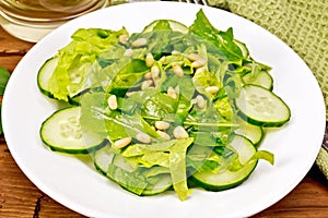 Salad from spinach and cucumber with napkin on wooden board