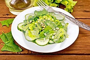 Salad from spinach and cucumbers with cedar nuts on table