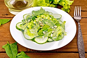Salad from spinach and cucumbers with lettuce on table