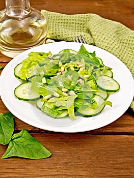 Salad from spinach and cucumbers with napkin on table