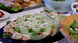 Salad with spinach and goat cheese onion red pepper in a wooden plate on the buffet table different food in portions