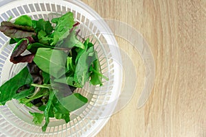 Salad and spinach leaves on wooden kitchen table with copy space, top view. Cooking dinner, lifestyle. Fresh healthy eating